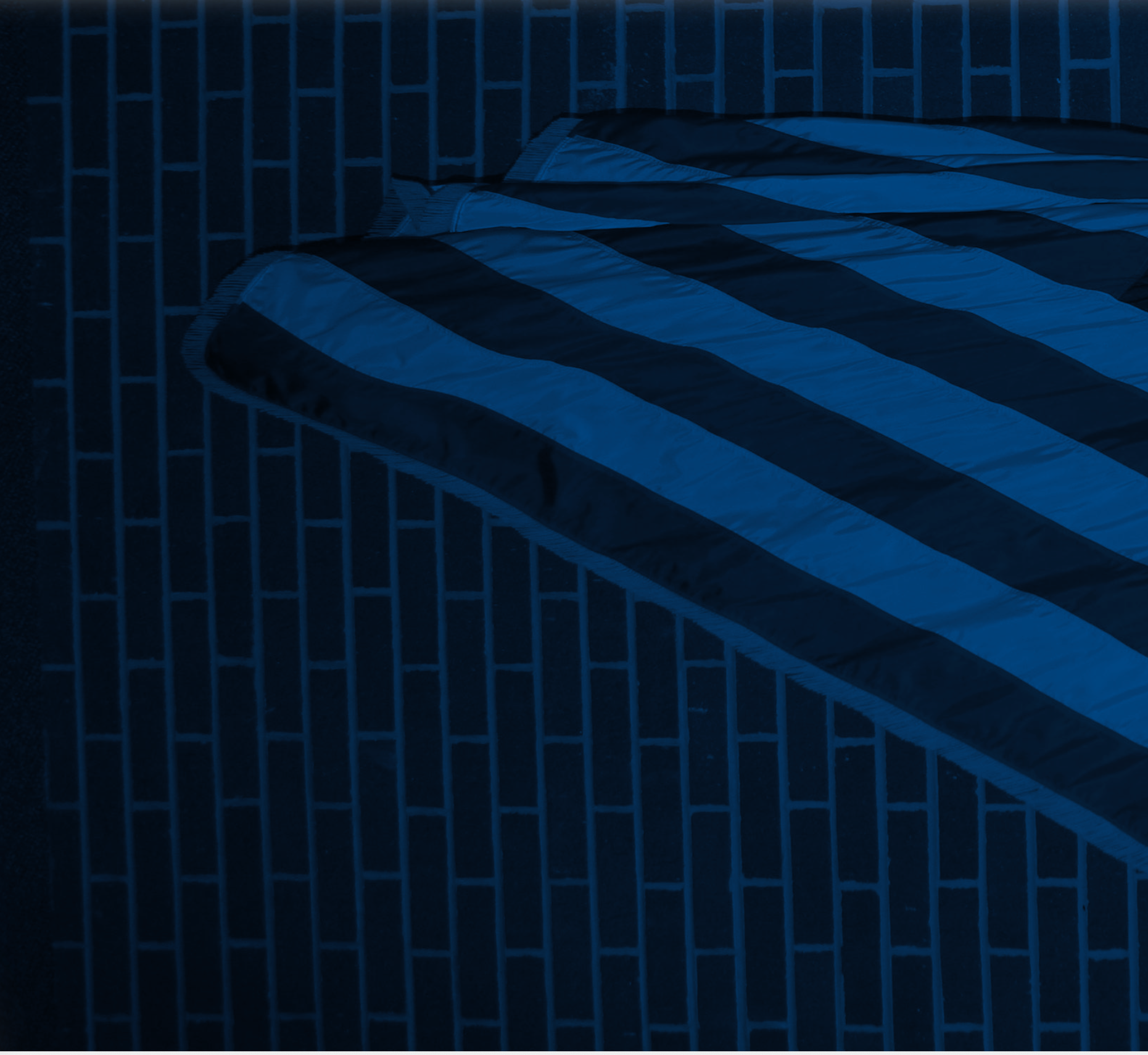 A folded American flag against a brick wall